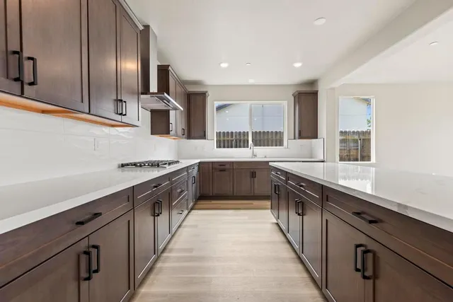 a large kitchen with stainless steel appliances double sink and a large window