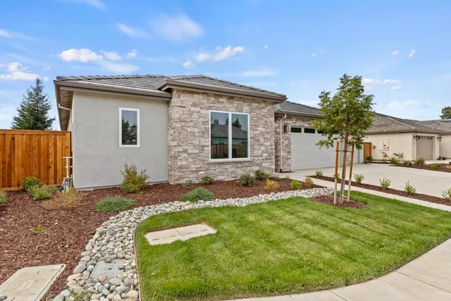 a front view of house with a garden
