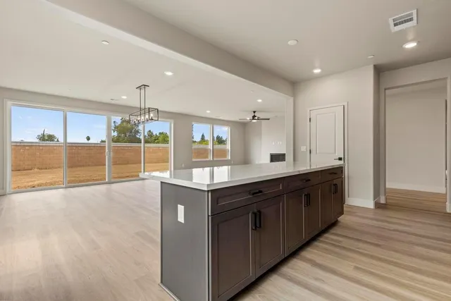 a large kitchen with stainless steel appliances granite countertop a large counter top and wooden floors