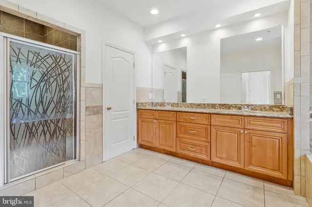 a spacious bathroom with a granite countertop sink a mirror and a
