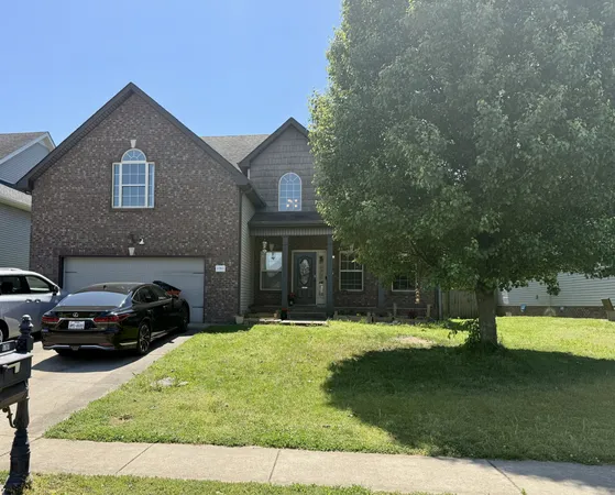 a front view of a house with a garden and trees