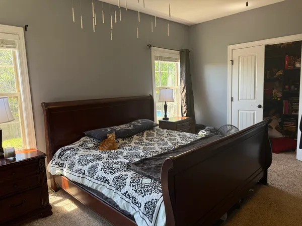 a kitchen with stainless steel appliances kitchen island granite countertop a refrigerator a stove top oven and a sink with wooden floor