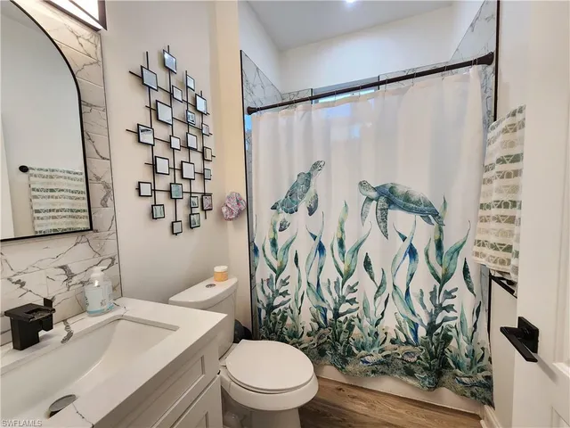 a bathroom with a sink a toilet and shower curtain