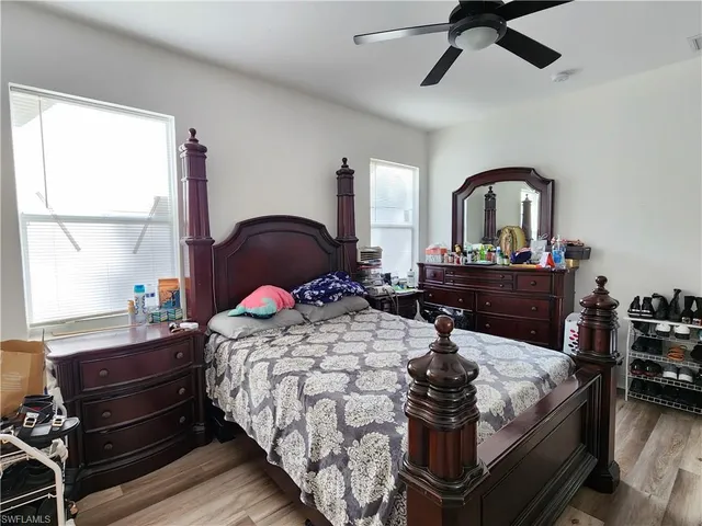 a bedroom with a bed and a dresser with window