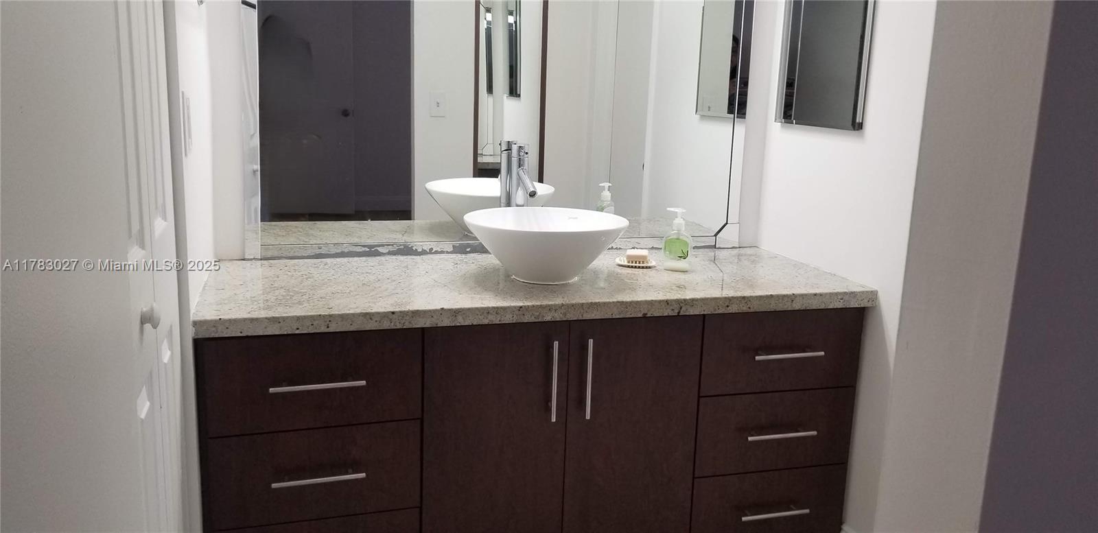 8850 Southwest 123rd Court, Unit H302 Miami, FL 33186 - Photo 12 of 28 a bathroom with a granite countertop sink and a mirror