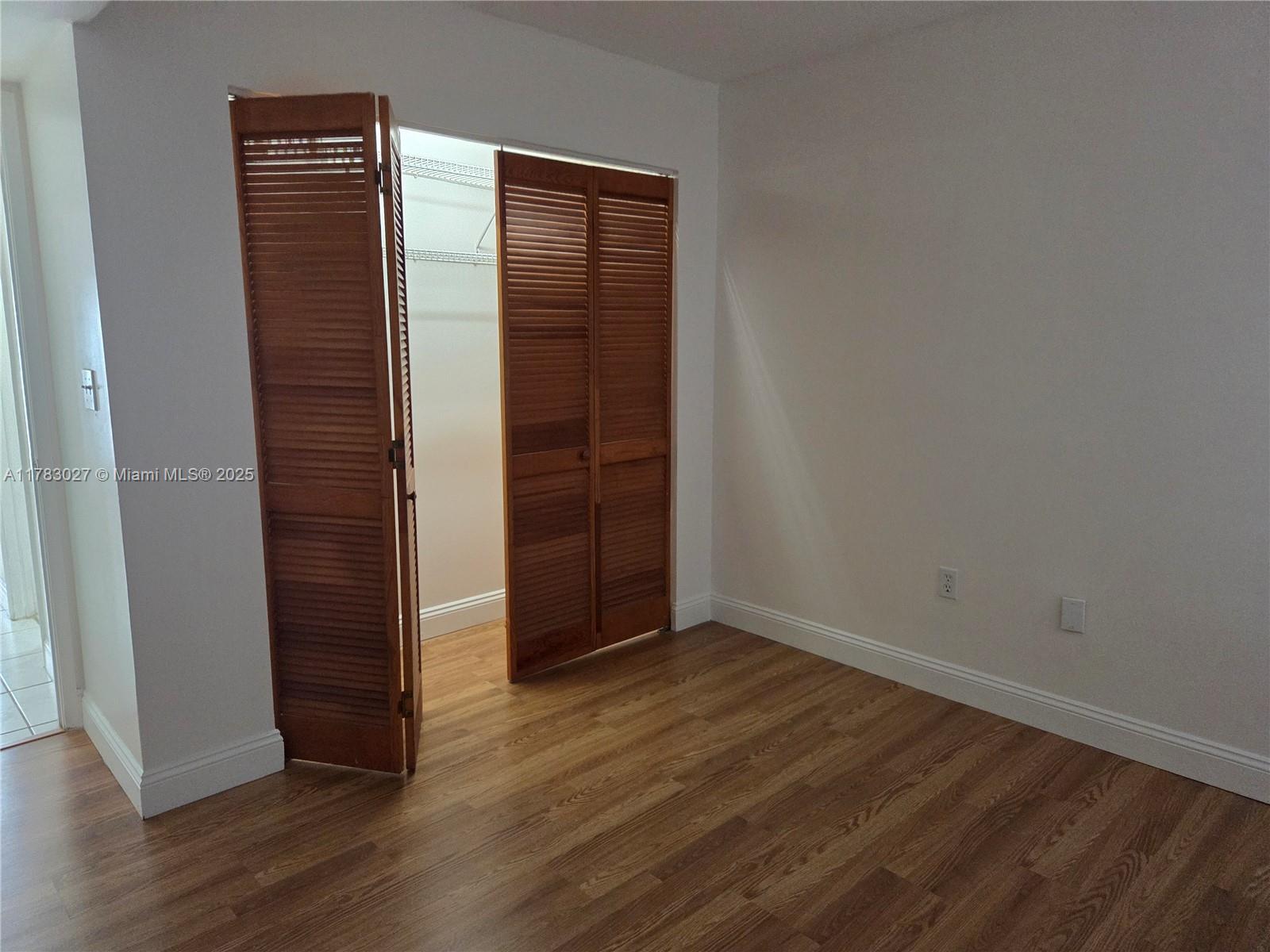 8850 Southwest 123rd Court, Unit H302 Miami, FL 33186 - Photo 18 of 28 an empty room with wooden floor and closet