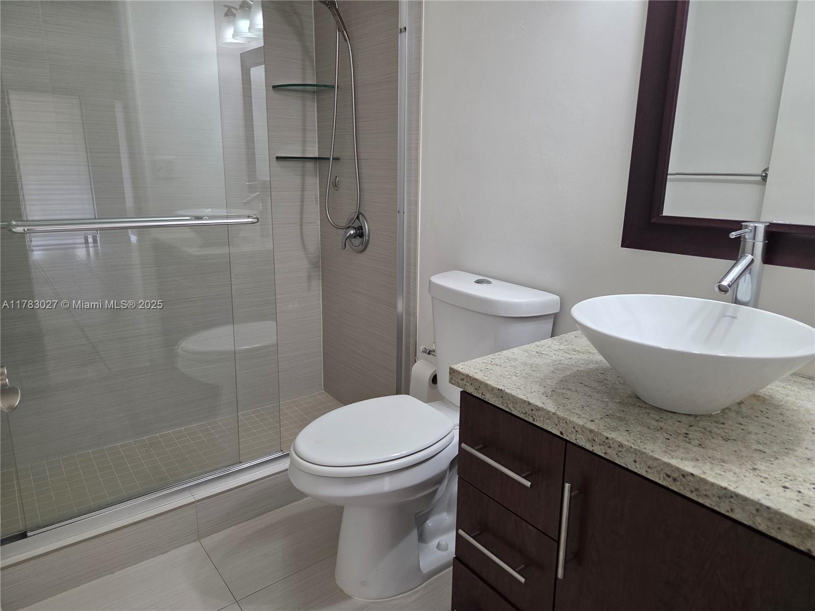 8850 Southwest 123rd Court, Unit H302 Miami, FL 33186 - Photo 19 of 28 a bathroom with a granite countertop sink toilet and shower
