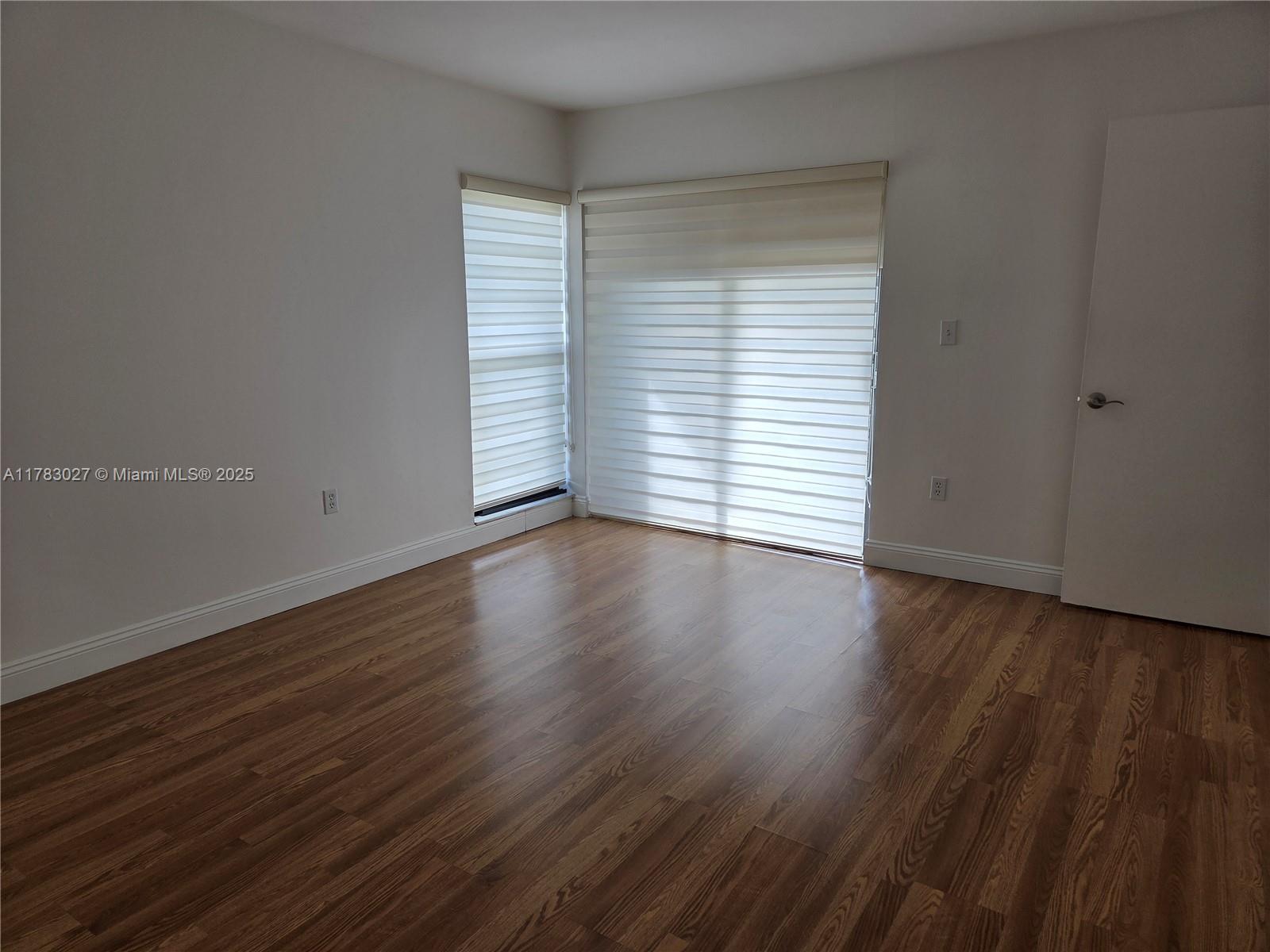 8850 Southwest 123rd Court, Unit H302 Miami, FL 33186 - Photo 9 of 28 an empty room with wooden floor and windows