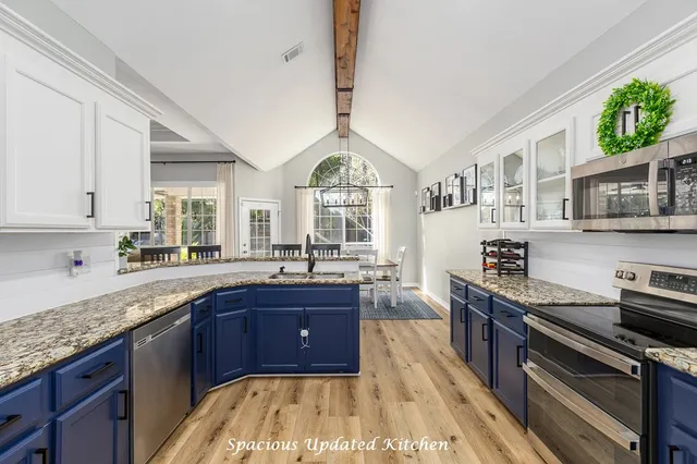 a kitchen with stainless steel appliances granite countertop a sink stove and cabinets