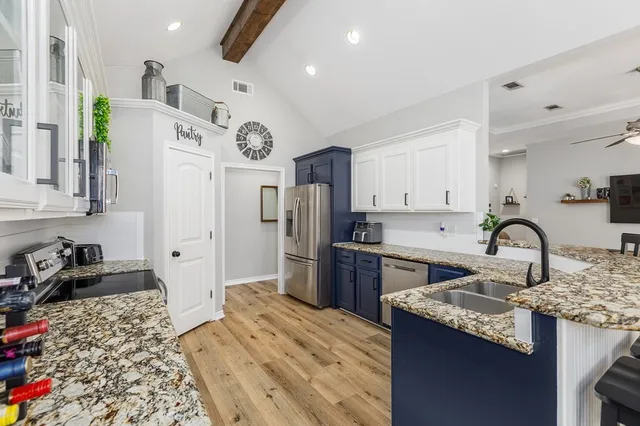 a kitchen with a refrigerator and a stove top oven