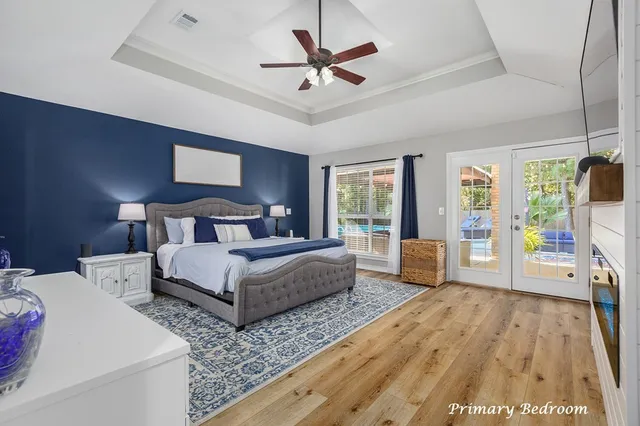 a bedroom with bed and a large window with wooden floor