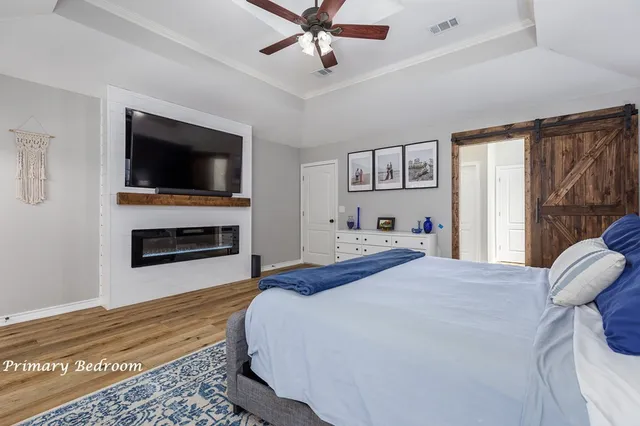 a spacious bedroom with a bed and a flat screen tv