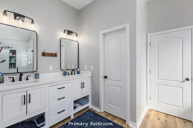 a bathroom with double vanity and a mirror