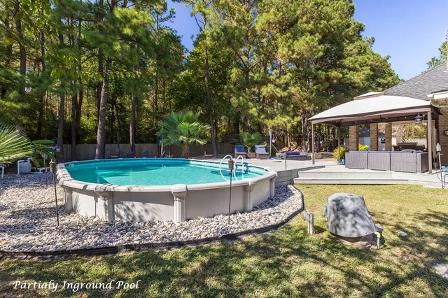 a view of a swimming pool with a table and chairs in patio