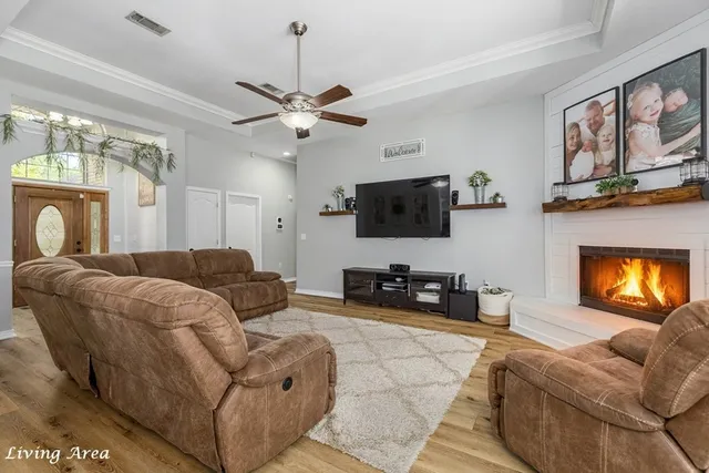 a living room with furniture a flat screen tv and a fireplace