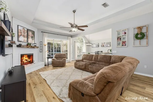 a living room with furniture a fireplace and a chandelier