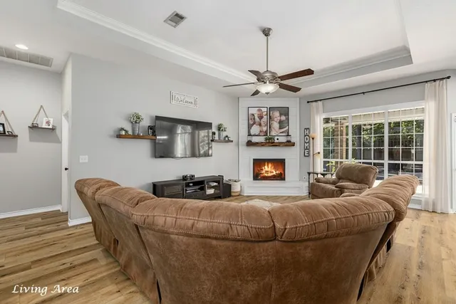a living room with furniture a fireplace and a chandelier