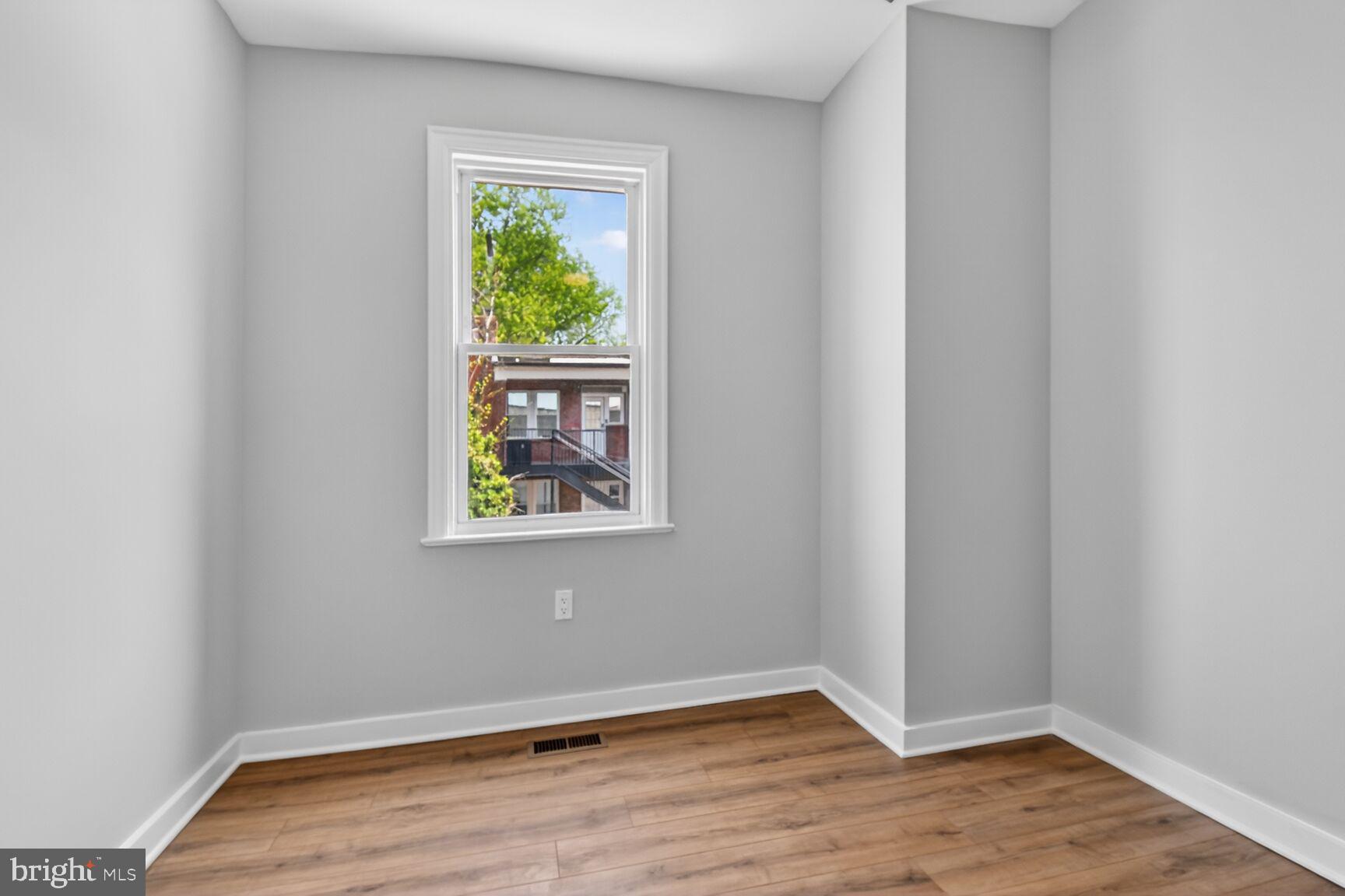 305 Decatur Street Northwest Washington, DC 20011 - Photo 18 of 21 a view of an empty room with wooden floor and a window
