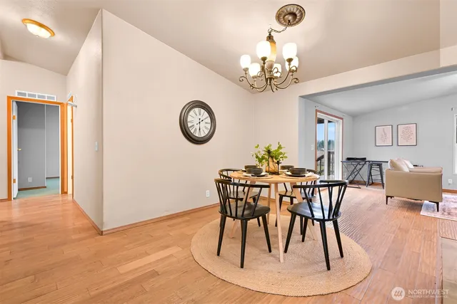 a view of a dining room with furniture a chandelier and wooden floor