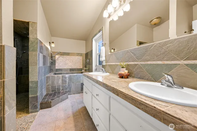 a spacious bathroom with a granite countertop sink a mirror and a shower