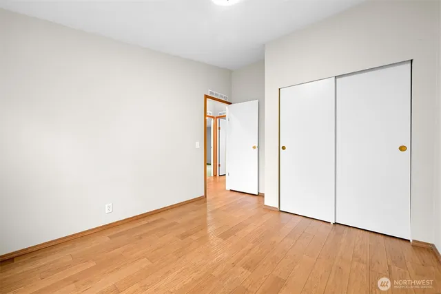 an empty room with wooden floor and white doors