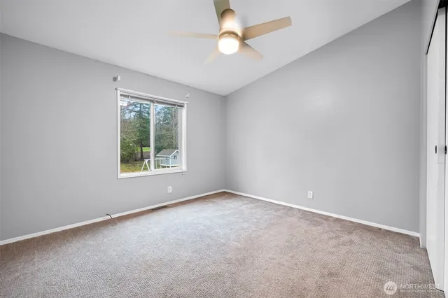 an empty room with a window and a fan