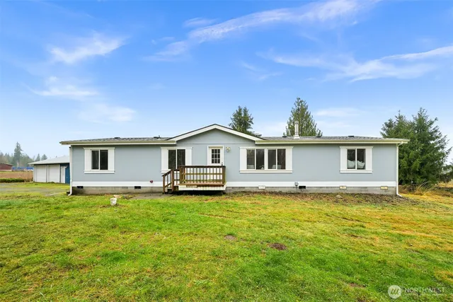 a big white house with a big yard and large trees
