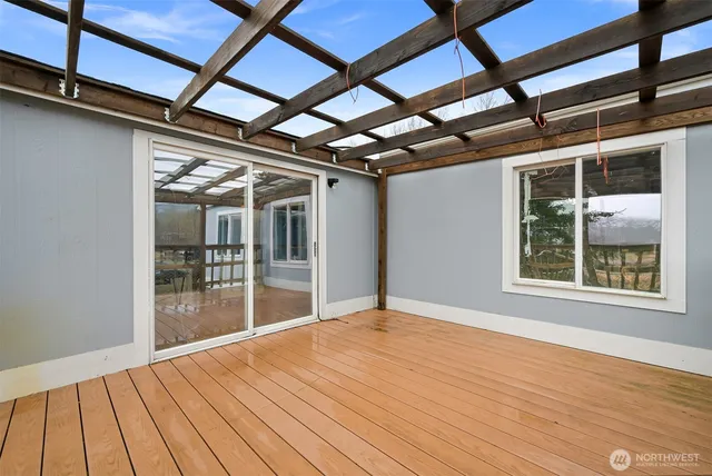 a view of an empty room with wooden floor and windows