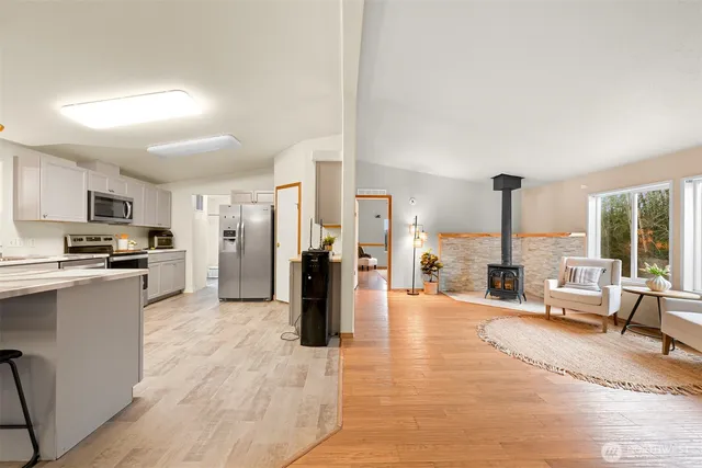 a large living room with stainless steel appliances kitchen island granite countertop a large cabinets and a table