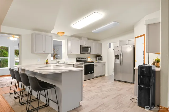 a kitchen with refrigerator a sink and chairs