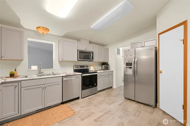 a kitchen with stainless steel appliances a refrigerator sink and stove