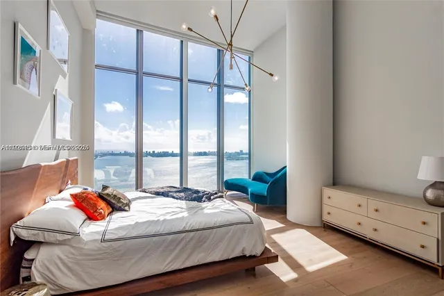 a bedroom with a bed and a large window