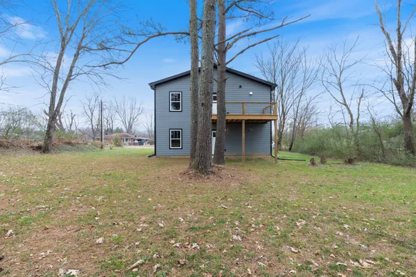 a view of a house with backyard and trees