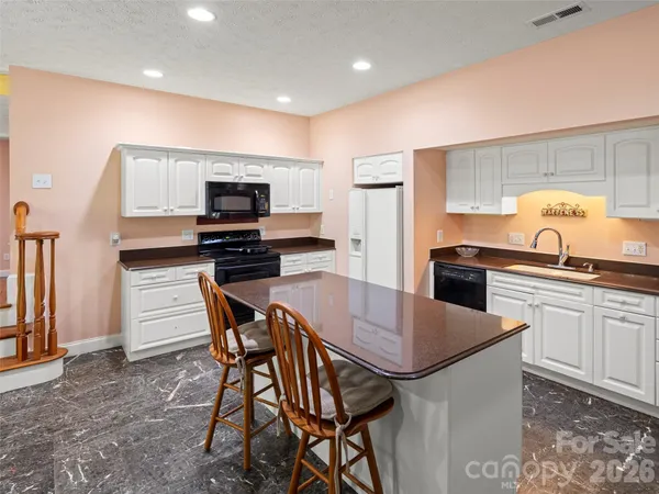 a kitchen with a table chairs microwave and refrigerator