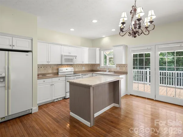 a kitchen with stainless steel appliances granite countertop a sink cabinets a refrigerator and a stove