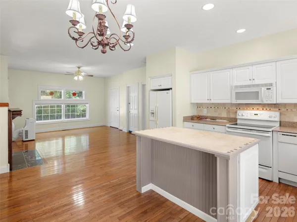 a kitchen with stainless steel appliances granite countertop a sink stove and wooden floor