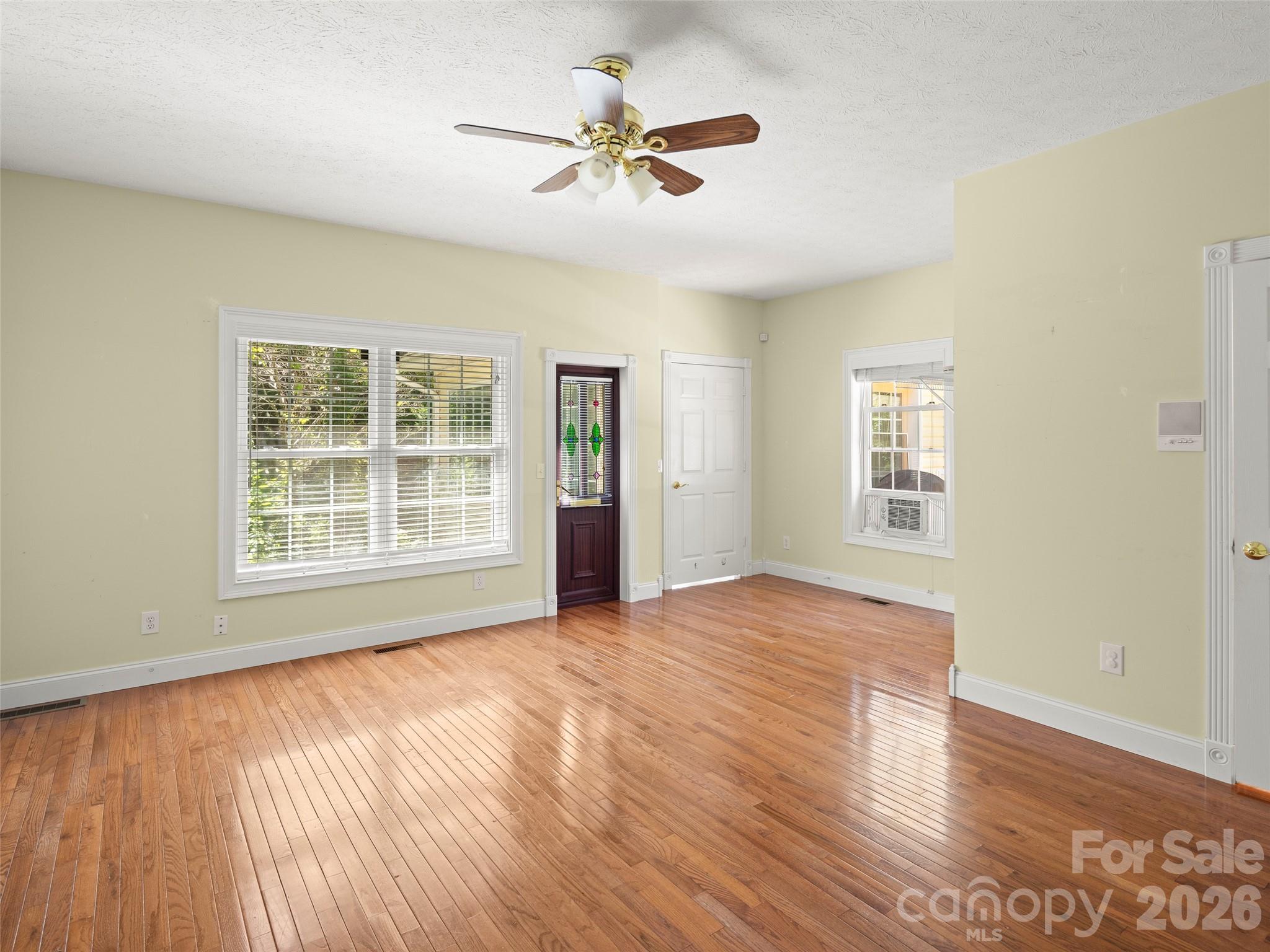 4901 Brevard Road Horse Shoe, NC 28742 - Photo 22 of 34 a view of an empty room with a window and wooden floor