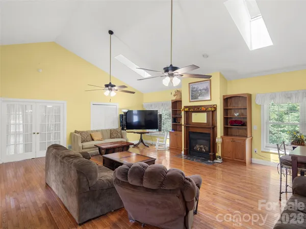 a living room with furniture a flat screen tv and a large window