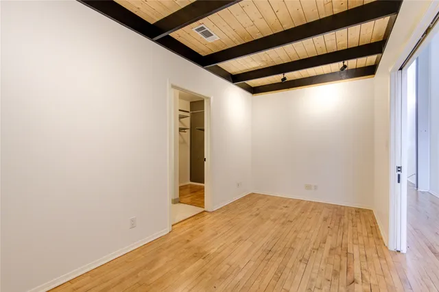 a view of a room with wooden floor and a window
