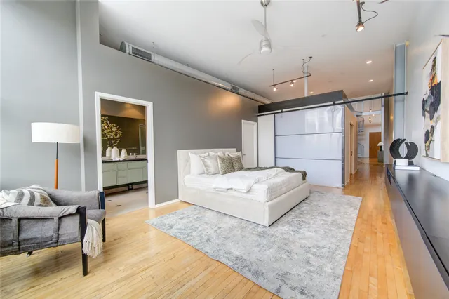 a spacious bedroom with a bed a couch and a potted plant