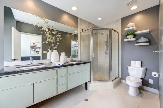 a bathroom with a double vanity sink mirror and toilet