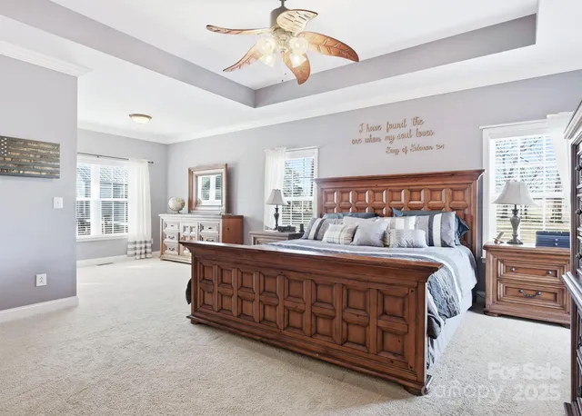 a large bed sitting in a room next to a window and a chandelier