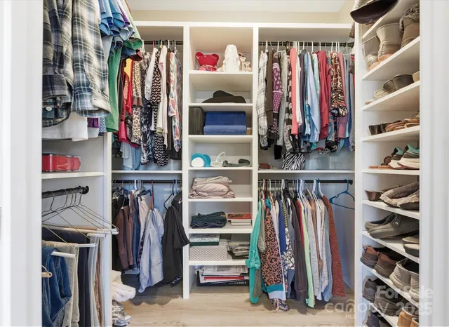 a view of walk in closet with clothes and shoes