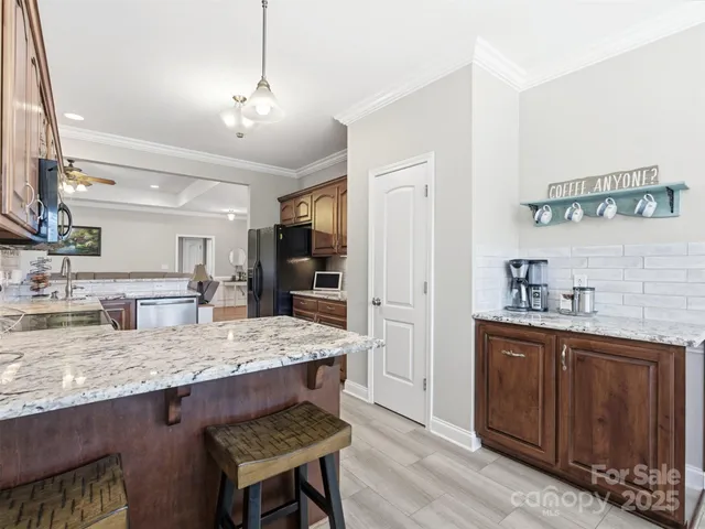 a kitchen with granite countertop a sink cabinets and wooden floor