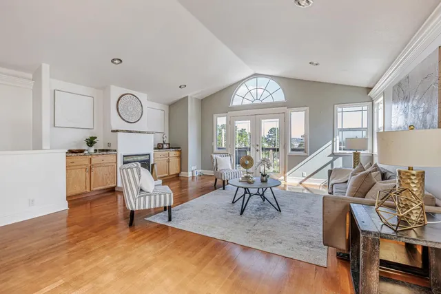 a living room with furniture a fireplace and a large window