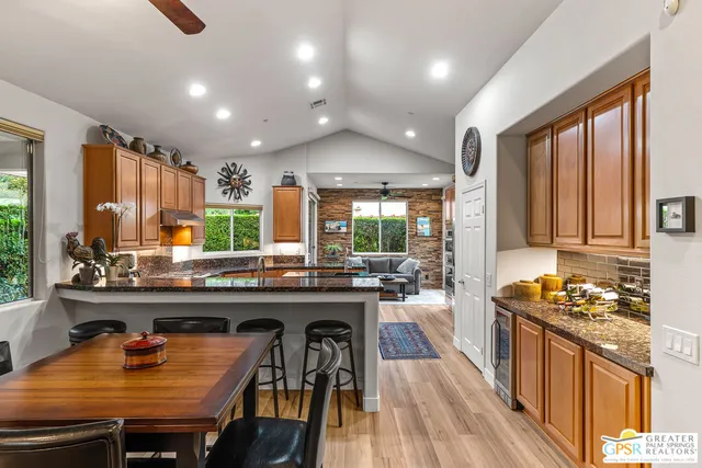 a kitchen with stainless steel appliances granite countertop a sink a refrigerator and a granite counter tops with a large window