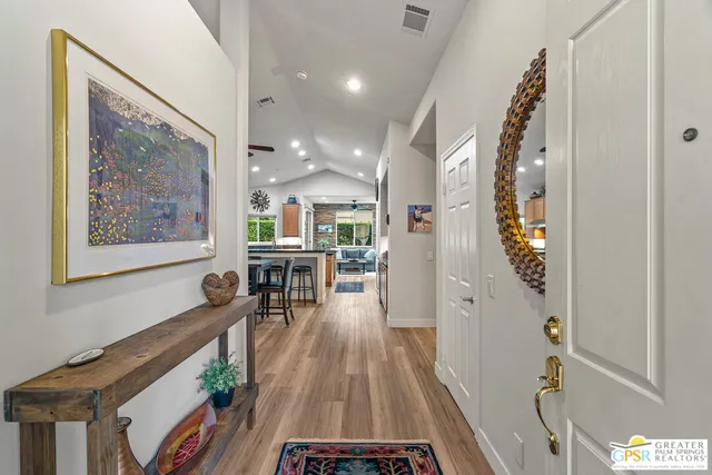 a view of a hallway with wooden floor and furniture