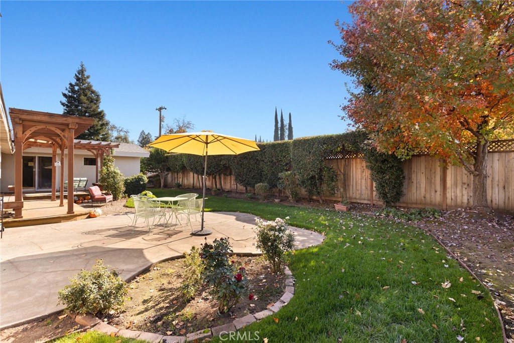 1075 Tracy Lane Chico, CA 95926 - Photo 24 of 29 a backyard of a house with table and chairs under an umbrella