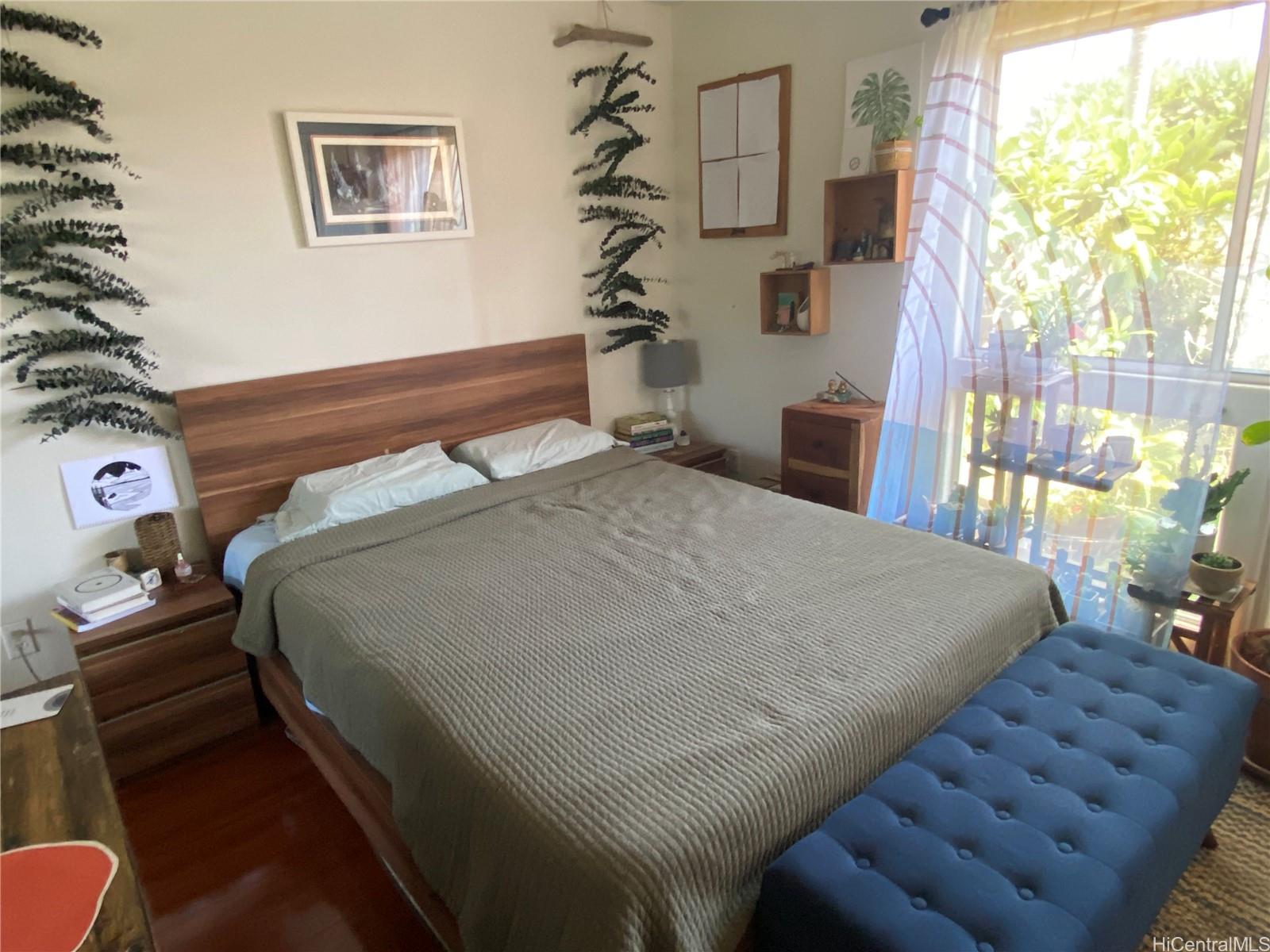 94-510 Lumiaina Street, Unit M103 Waipahu, HI 96797 - Photo 11 of 24 a bed sitting in a bedroom next to a window