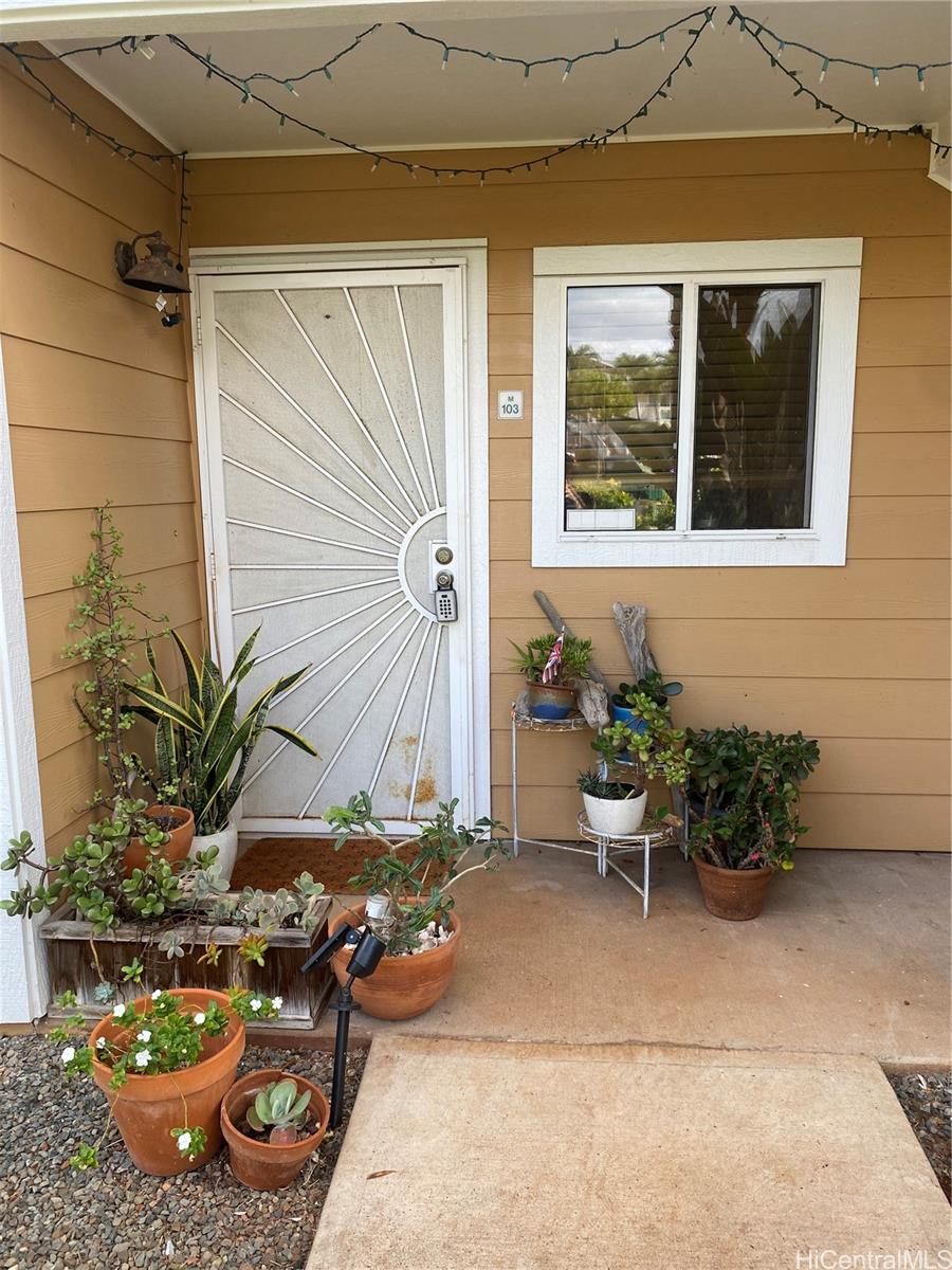 94-510 Lumiaina Street, Unit M103 Waipahu, HI 96797 - Photo 20 of 24 a view of a backyard with chair and potted plants